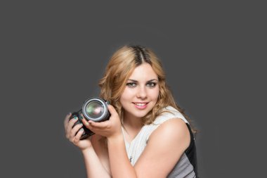 Elinde kamera olan genç bir kadın.