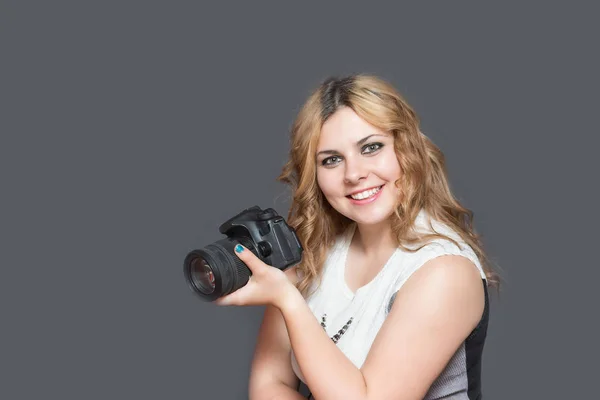 Jonge vrouw met een camera glimlachen — Stockfoto