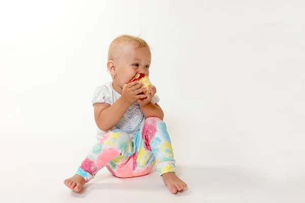 Γενική άποψη της δροσερό μικρό παιδί κάθεται το κορίτσι τρώει κόκκινο μήλο — Φωτογραφία Αρχείου