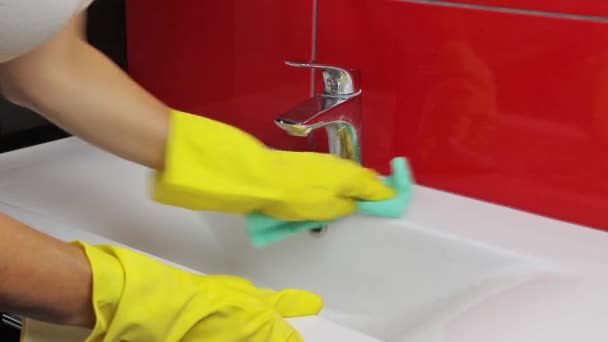 Hausfrau in gelben Handschuhen putzt das Waschbecken — Stockvideo