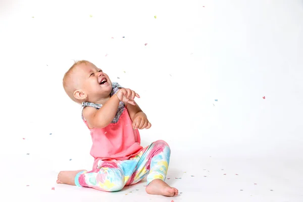 Riant tout-petit fille est en train de regarder le papier confettis fallin — Photo