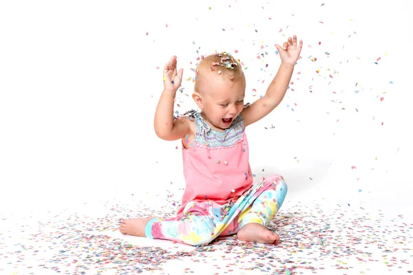 Laughing toddler girl with raised hands is looking at the floor — Stock Photo, Image