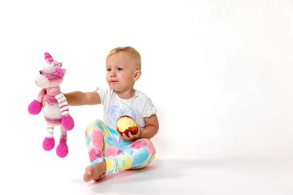 Studio shot van peuter meisje holding rode appel en stof speelgoed — Stockfoto