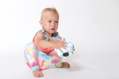 Yürümeye başlayan çocuk kız kaydetme bir kumbara ile oynuyor