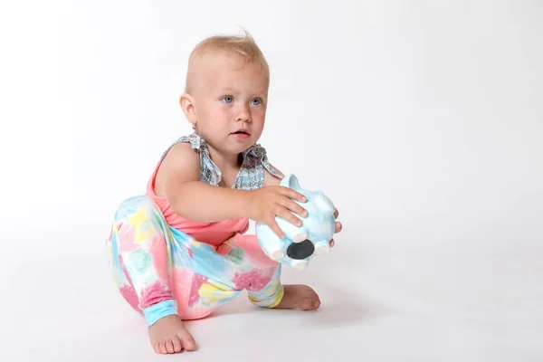 Kleuter meisje speelt met een opslaan piggy bank — Stockfoto