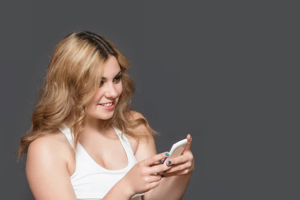 长头发年轻妇女的画像用智能手机 — 图库照片