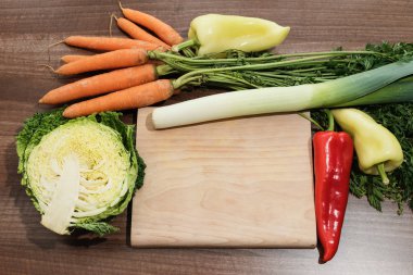 The kitchen desk is surrounded by fresh vegetables