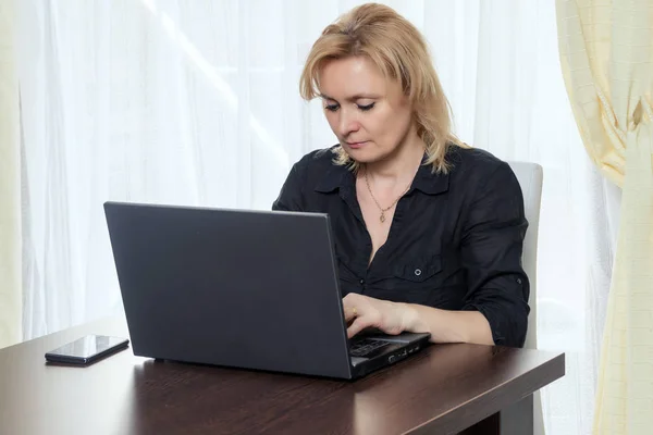 Middelste leeftijd vrouw werkt in het bureau thuis. — Stockfoto