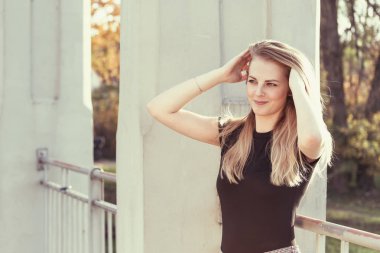 Çekici kız uzun saçlarını elleriyle tarıyor.