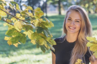 Gülen uzun saçlı genç kızın açık hava portresi 