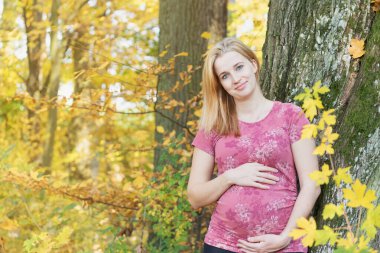 Genç hamile kadın karnını tutuyor.