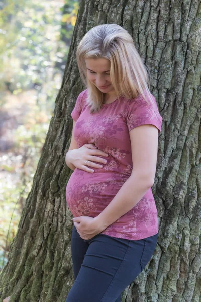 Jeune femme tient son ventre de grossesse . — Photo