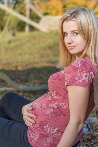 Vue latérale de la jeune femme enceinte assise — Photo