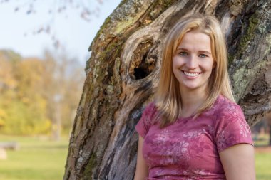 Açık havada gülen güzel bir genç kadının portresi.