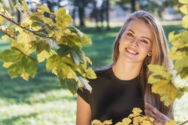 Gülümseyen, çekici, uzun saçlı genç kızın portresi. 