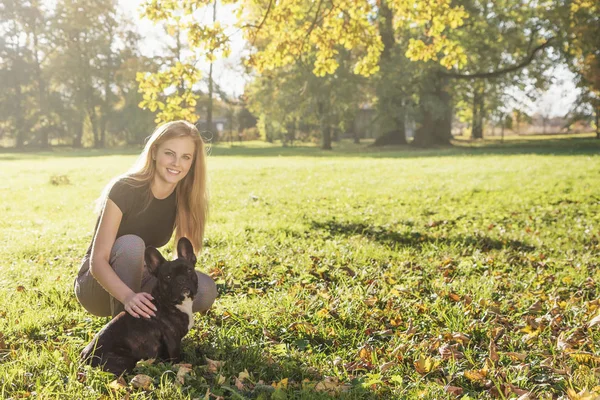 Fiatal lány pózol francia Bulldog őszi parkban — Stock Fotó