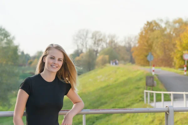 Krásná mladá dívka je pózování vedle cyklistické stezky — Stock fotografie