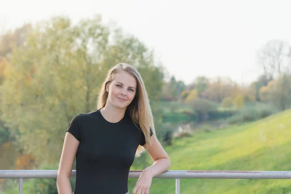 Krásná mladá dívka stojí na mostě — Stock fotografie