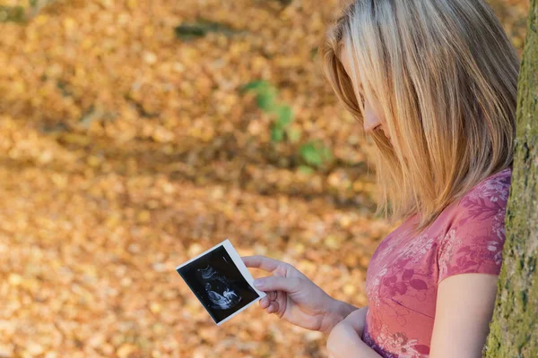 Jeune femme enceinte regarde plan de l'espace de son enfant à naître — Photo