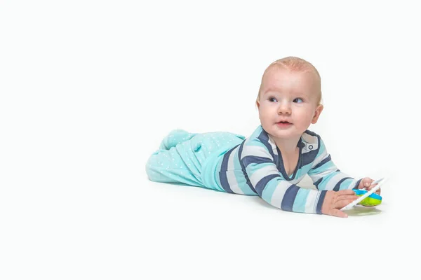 Mignon bébé garçon est couché sur fond blanc tenant un jouet . — Photo