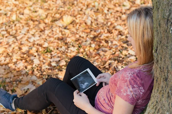 Femme enceinte regarde plan de l'espace de son enfant à naître outs — Photo