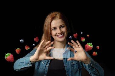 Gülümseyen genç bir kadın elinde mavi şeffaf dikdörtgen tutuyor, mesajınız için hazır çilekler, ahududular ve yabanmersinleri uçuşuyor..