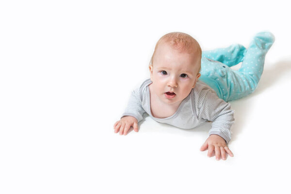 Surprised cute little baby boy is lying and looking at the camera. All on the white background