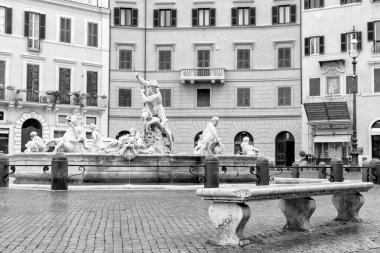 Roma 'daki Navona Meydanı' ndaki Neptün Çeşmesi 'nin (Piazza Navona) önündeki boş taş bankın siyah ve beyaz fotoğrafı. İtalya. Tüm potansiyel markalar kaldırıldı.