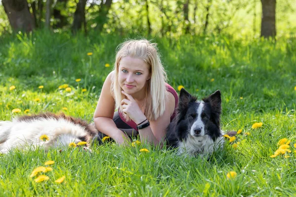Smiling Young Blond Woman Lying Two Border Collies Dogs Outdoors — Stock Photo, Image