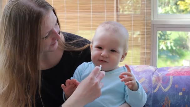 Mãe no cuidado do bebê dando seu bebê um spray nasal para resfriados — Vídeo de Stock