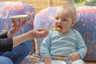 Anne bir yaşındaki oğlunu lapayla besliyor..