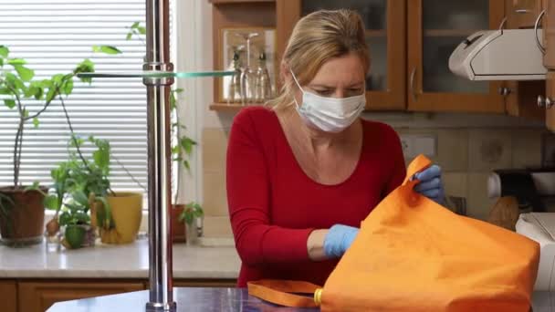 Жінка розпаковує частину покупки під час пандемії коронавірусу — стокове відео