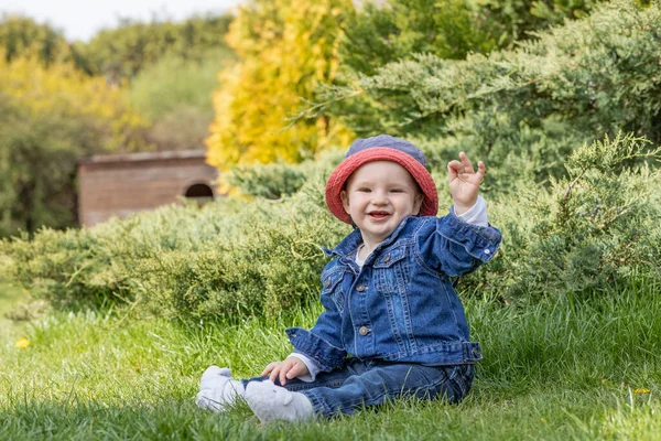 Sorridente Piccolo Bambino Seduto All Aperto Gesticolare Positivamente Alla Fotocamera — Foto Stock