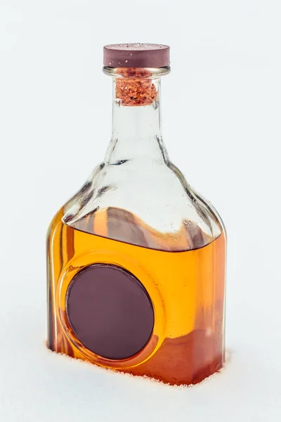 Elit alkol ve karda mum mühür ile cam şişe. Lüks sert içki. Metniniz için kopya alanı.