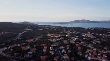 İtalya, Sardinya 'da güzel bir köyün havası. Sahilde gün doğumu, dağlar