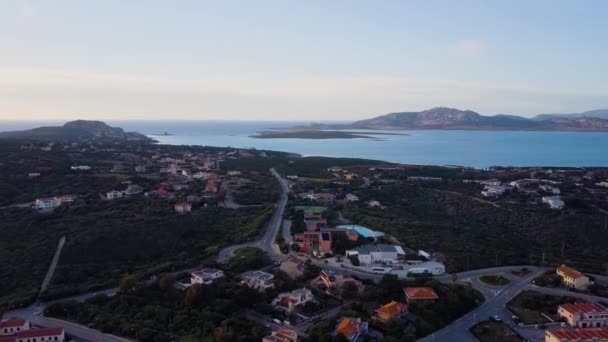 Aérea de un bonito pueblo en Cerdeña, Italia. Salida del sol en la costa, montañas — Vídeo de stock