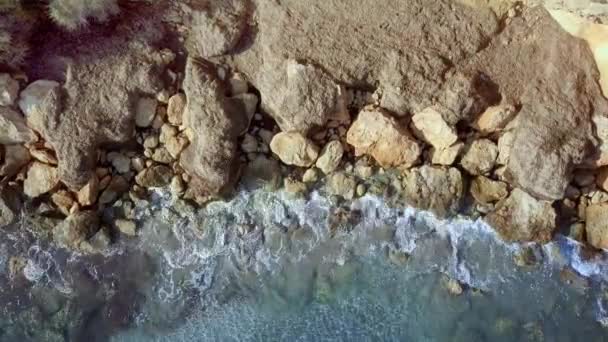Vue aérienne magnifique. Les vagues se lavent sur les pierres et les cailloux sur le rivage. Calpe Espagne — Video