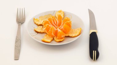 Natürmort - bir daire üzerinde açık bir mandarin sonraki bıçak ve çatal.
