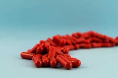 Kapsüller bir uyuşturucu madde ile mavi bir arka plan üzerinde bir yay şeklinde girildi.