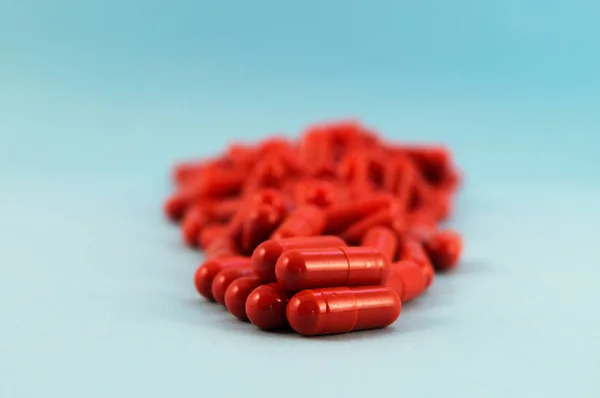 Red Capsules Medicine Stacked Blue Background Focus Foreground — Stock Photo, Image