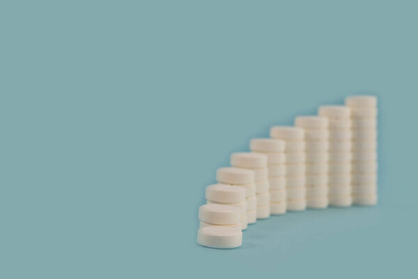 White tablets, laid in the form of an increasing and smoothly curved diagram.