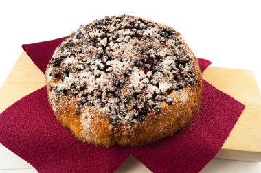 Beyaz bir arka plan üzerinde beyaz şeker tozu ile serpilir Siyah frenk üzümü ile ev yapımı yuvarlak pasta.