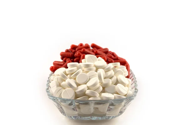 Comprimidos Redondos Blancos Cápsulas Rojas Apilados Una Placa Transparente Vidrio — Foto de Stock