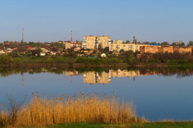 Sabahın erken saatlerinde göl sakin ve düz yüzey çok katlı binaların yansıma.