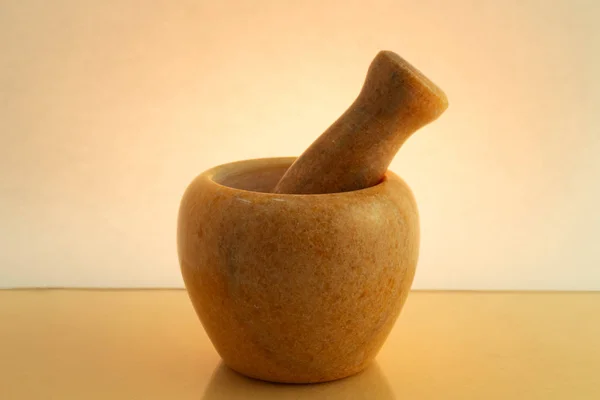 Mortar and pestle for grinding and mixing ingredients on a colored background in backlight with a gradient.