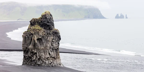 Großer Felsen am schwarzen Strand, Island — Stockfoto