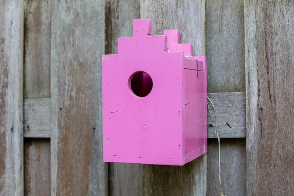 Pink birdhouse on a wooden fence — Stock Photo, Image