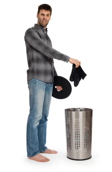 Young man putting dirty socks in a laundry basket