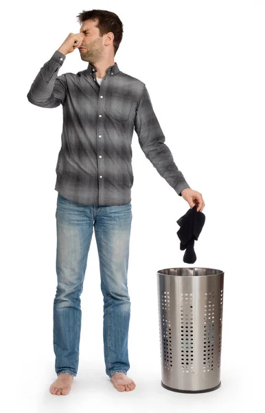 Young man putting dirty socks in a laundry basket