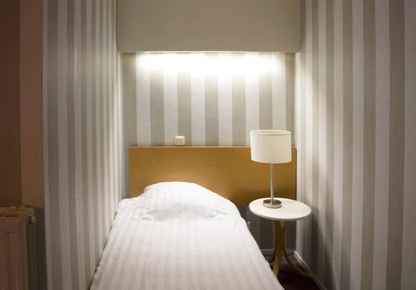 Простой номер в отеле, односпальная кровать — стоковое фото